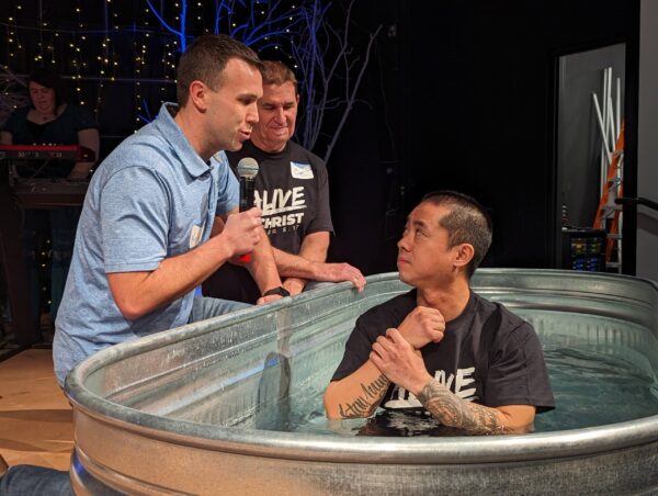 man getting baptized in a metal trough at COTR